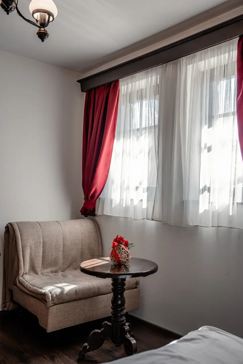 Armchair and side table by the window, portrait