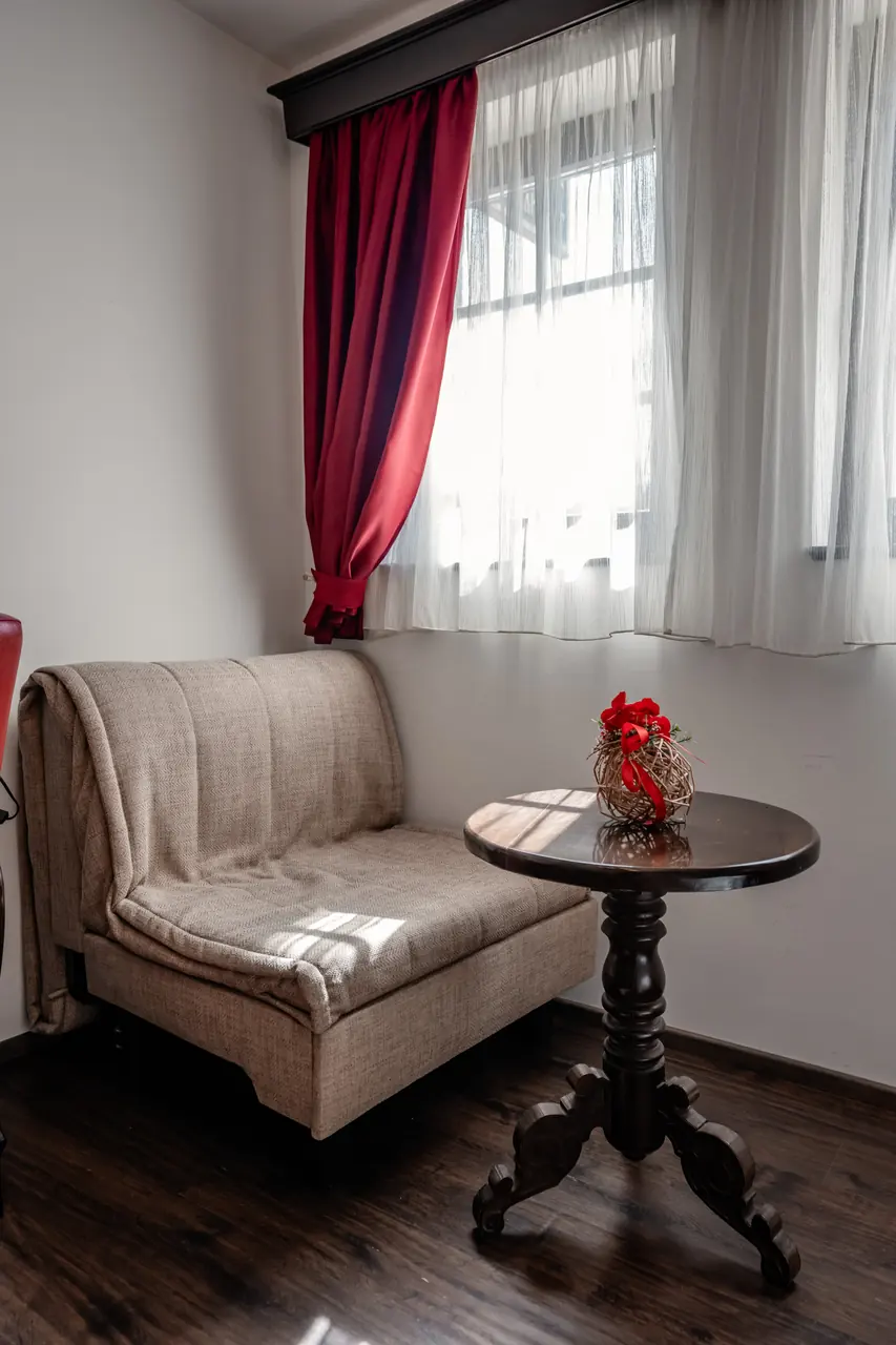 Armchair, table with flowers and window, portrait