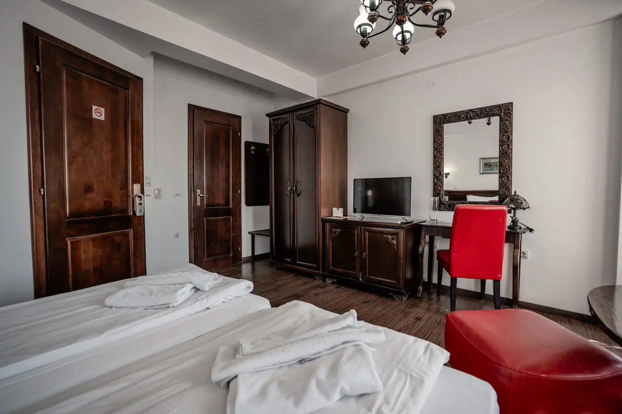 Beds, desk with red chair, entrance door