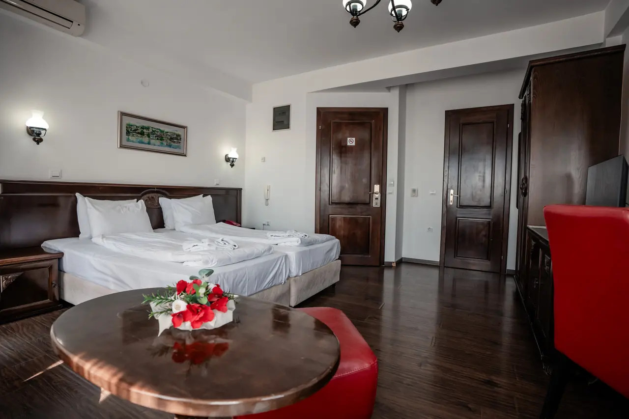 Round table with flowers in front, beds behind