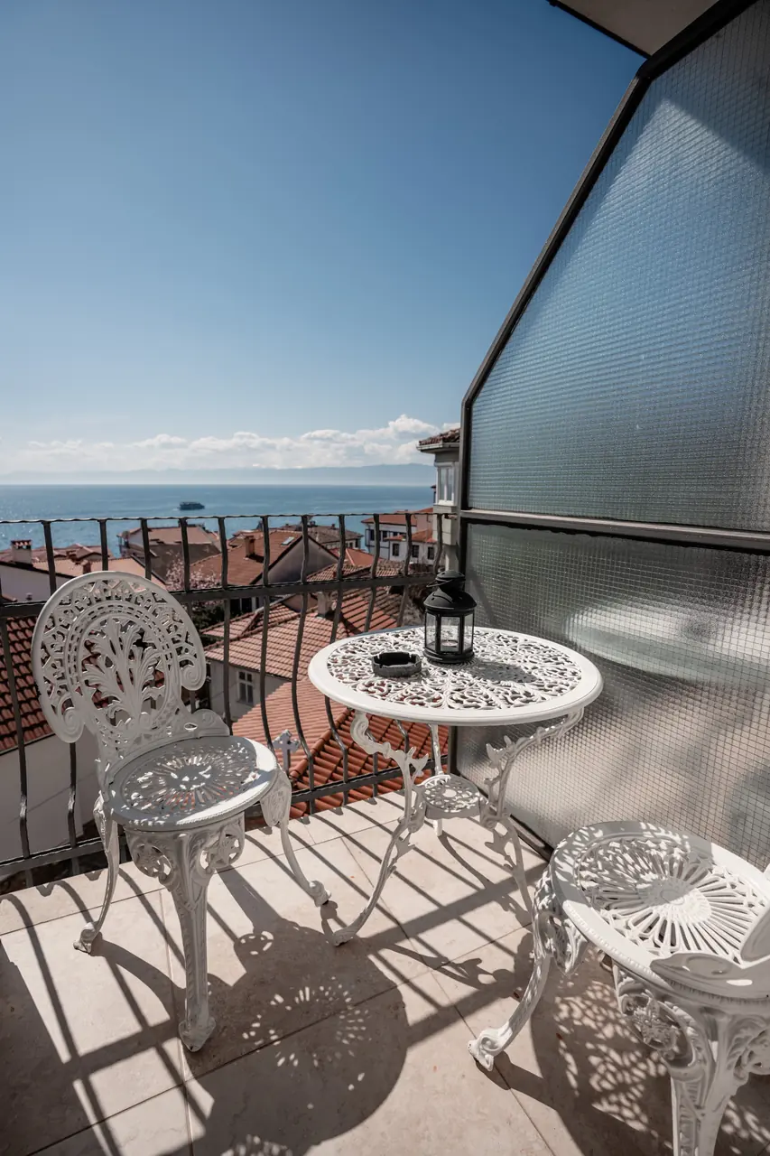 Wrought-iron table and chairs on a balcony looking out over the lake