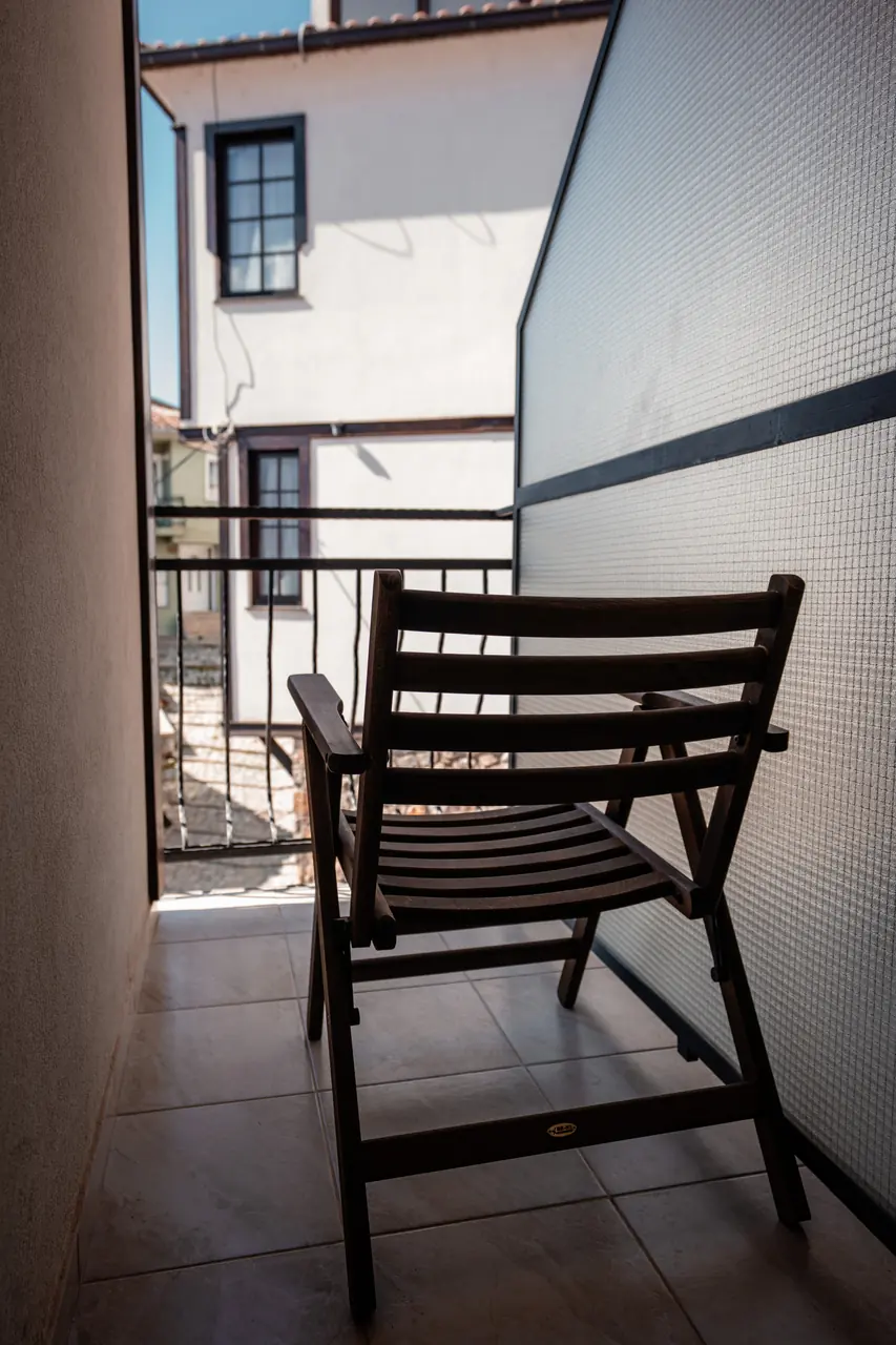 Balcony with wooden chair and neighbouring houses, portrait