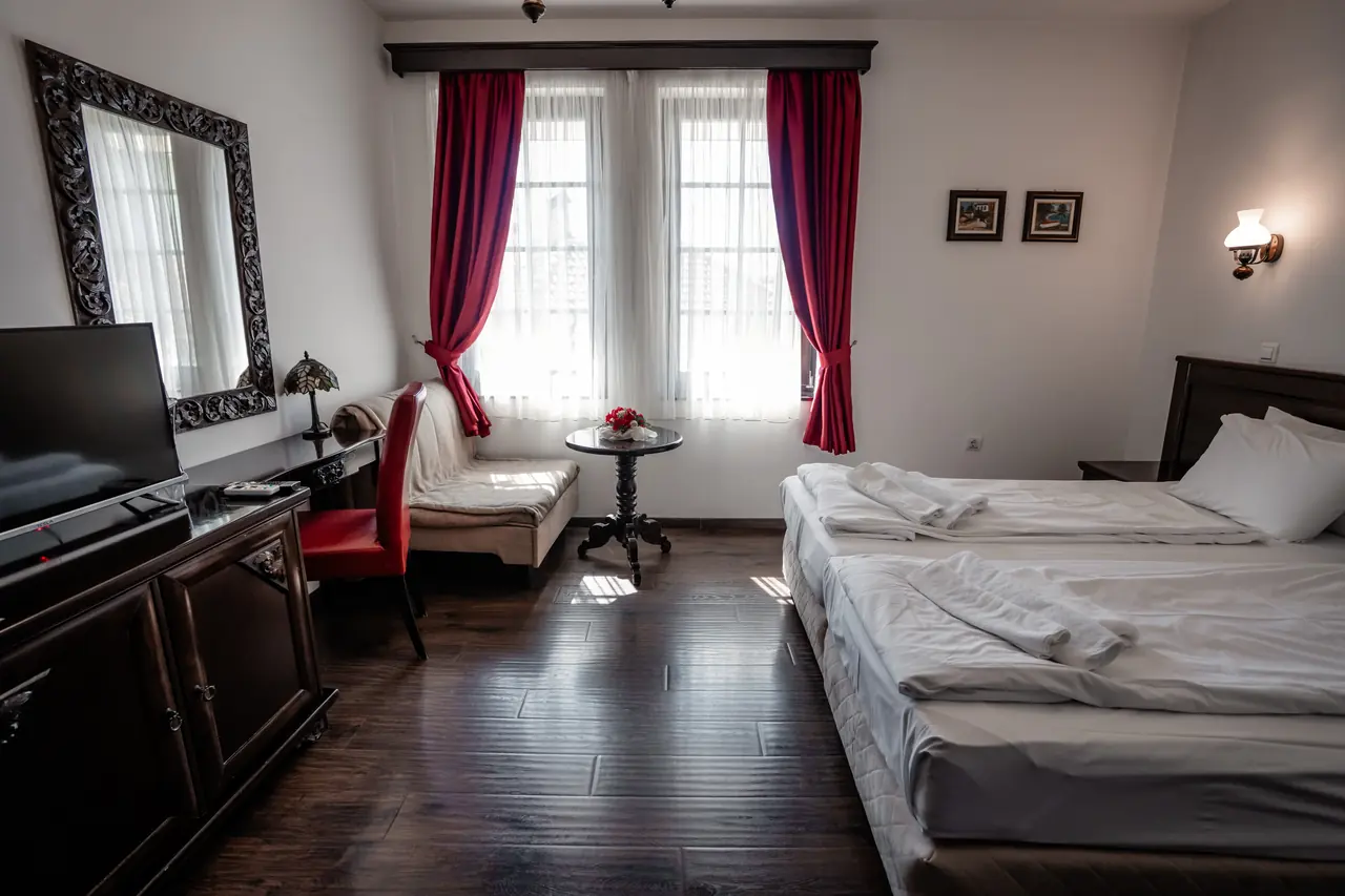Wide: TV unit on the left, beds on the right, windows