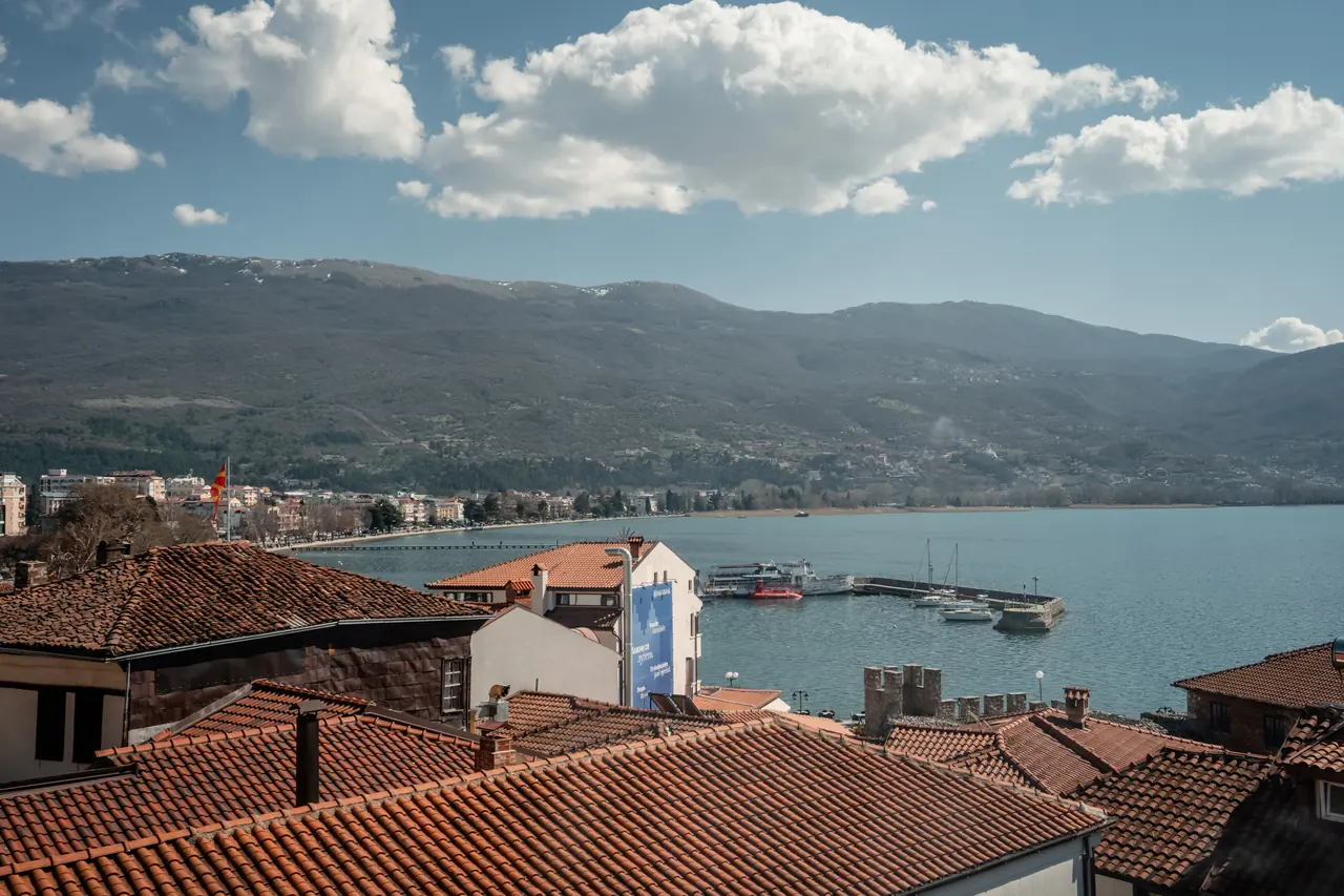 Window view: roofs, harbour, lake and mountains with clouds. One of the best views