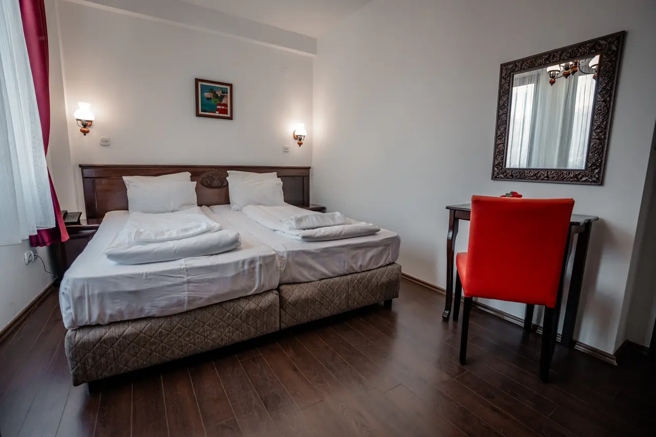 Wide: beds, red chair and carved mirror
