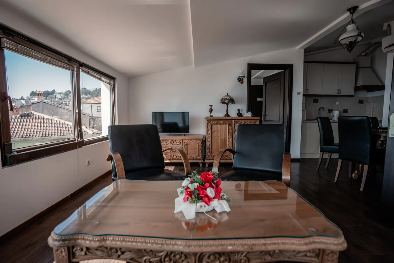 Coffee table with flowers, looking toward the dining corner and kitchenette