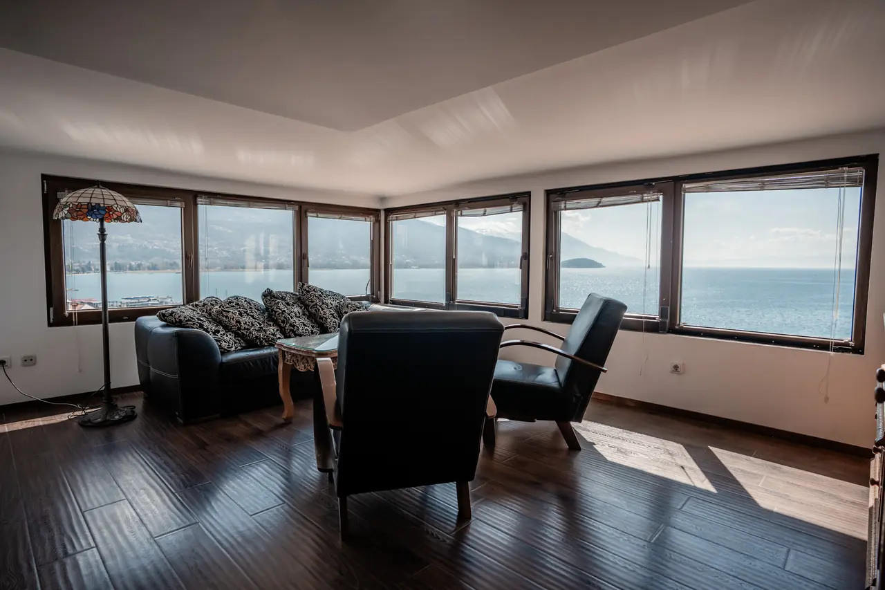 Wide living room with the corner window panorama over Lake Ohrid; best penthouse lead