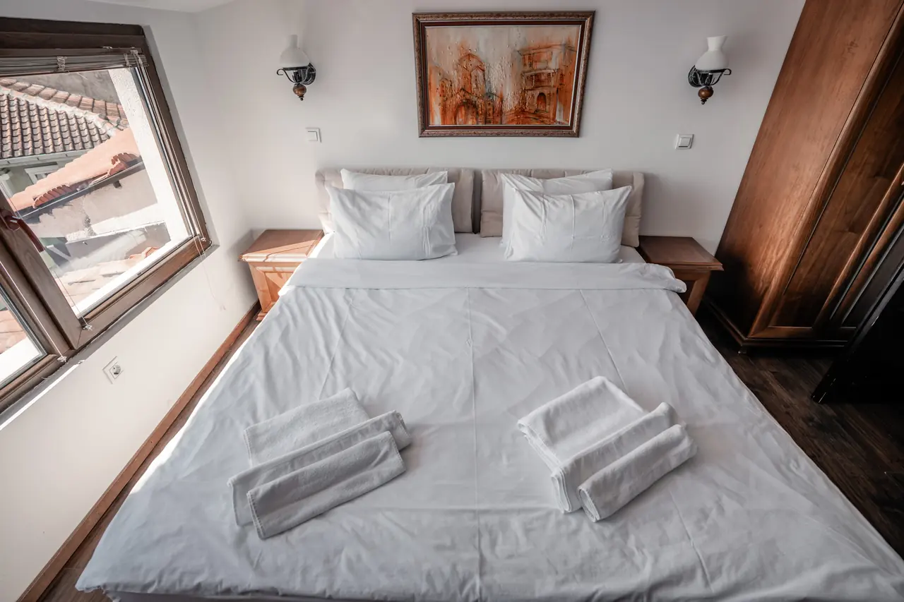 Bed seen from the foot, window onto the lake