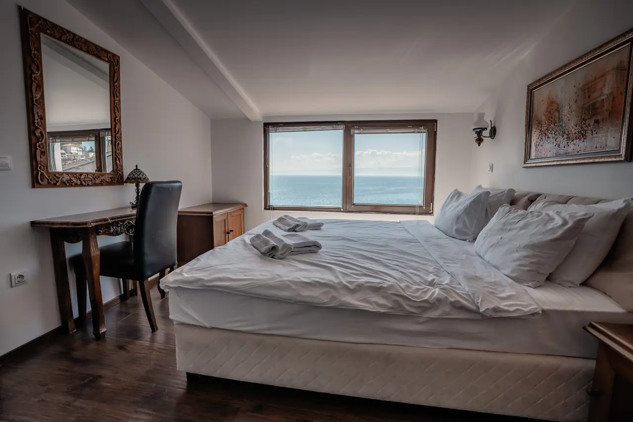 Bedroom with carved mirror and writing desk, window onto the lake