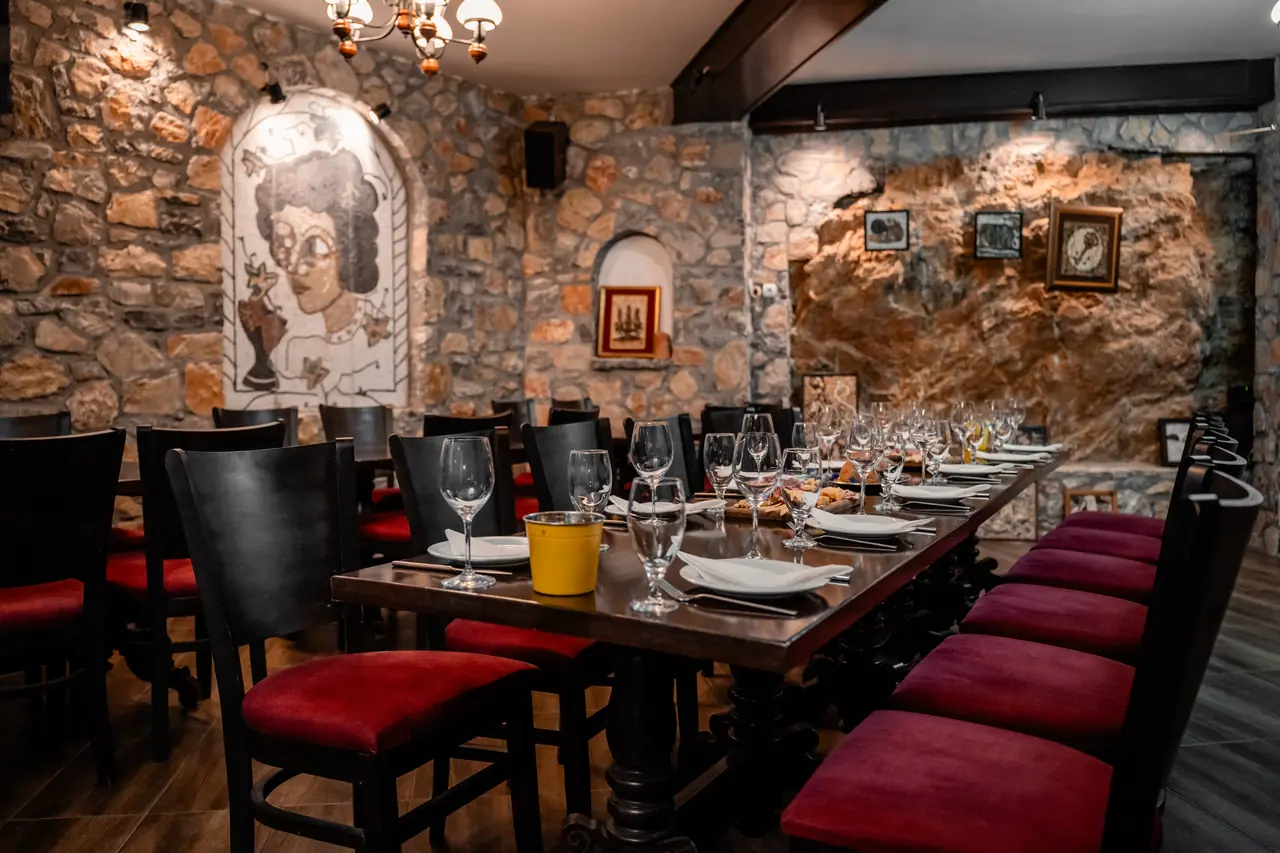 The stone wine bar with a long table set under pebble mosaics